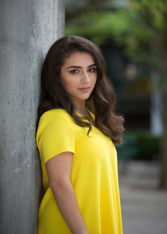 Seattle-based actor and writer Raya Tuffaha. Girl with brown hair in a yellow dress